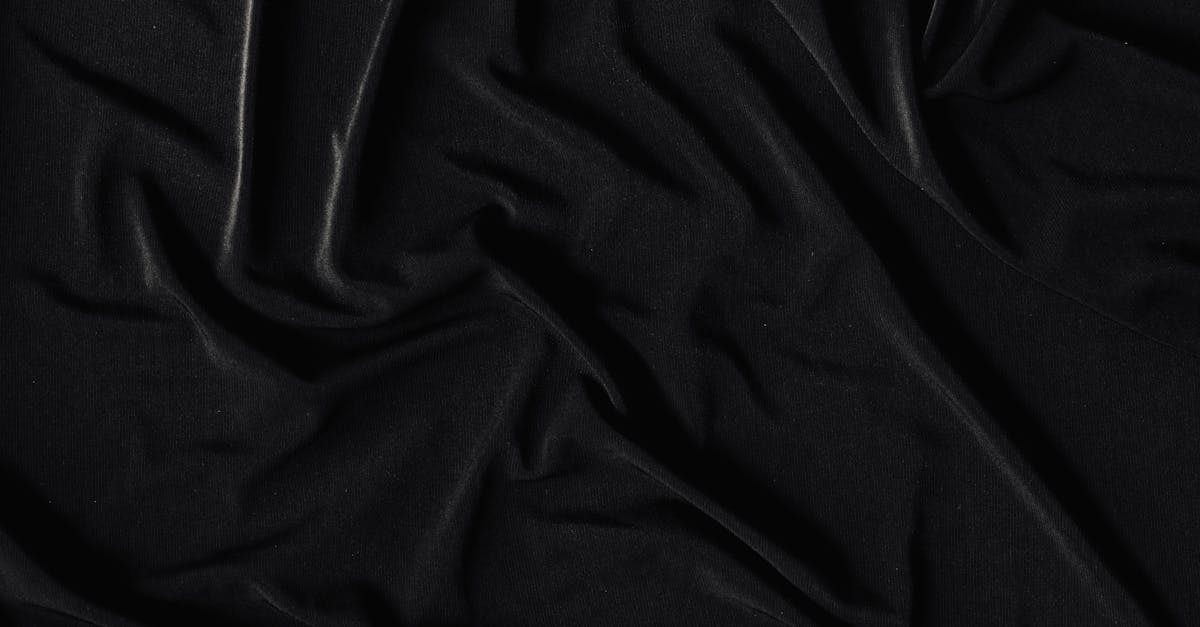 A detailed shot of a crumpled black fabric, showcasing its smooth and wrinkled texture in a monochromatic tone.